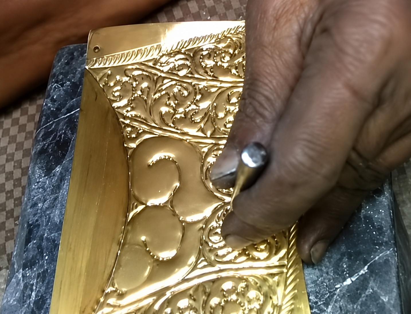 Hand chasing floral details into metal